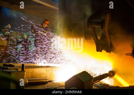 Temirtau, Kasachstan - 08. Juni 2012: Metallurgie-Anlage von Arcelor Mittal. Stahlherstellung. Arbeiter füttert Oxygen zum Schmelzen. Funken und Feuer. Stockfoto