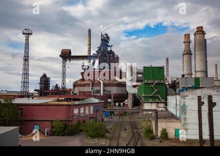 Blick auf die moderne Schmelzerei (Metallurgieanlage). Verrostete Metallhochöfen, Rauchschächte und Leuchttürme.; Stockfoto