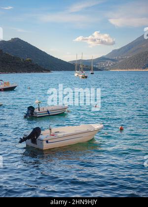 Kleine Fischerboote bei Sonnenuntergang - Kas Türkei. Boote und Berge an der türkischen Mittelmeerküste, beliebtes Touristenziel Stockfoto