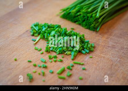 Frisch geschnittener grüner Schnittlauch auf Holzbrett zum Dekorieren des Hauptgericht Stockfoto