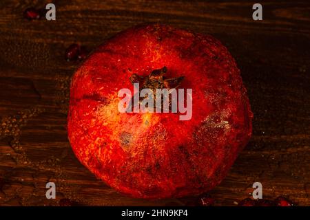 Roter, reifer, nasser Granatapfel auf dem Tisch. Nahaufnahme Stockfoto