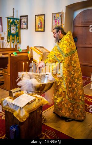 Mochov, Tschechische Republik - 13. Februar 2022: Orthodoxe Taufzeremonie in der römisch-katholischen Kirche St. Bartholomäus in Mochov, Tschechische Republik. Stockfoto