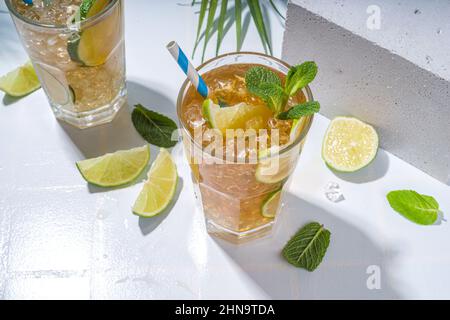 Cuba Libre, langer Eisteecocktail mit starkem Alkoholgetränk, Cola, Limette und Eis in zwei Gläsern, kalter Longdrink-Mocktail auf hellblau gefliestem Rücken Stockfoto