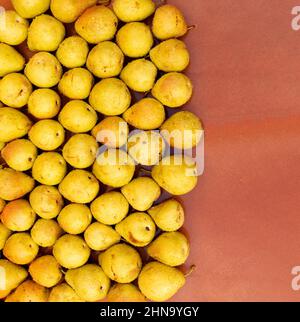 Viele Birnen in Reihen und Spalten auf braunem Hintergrund angeordnet Stockfoto