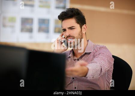 Schau dir das an. Aufnahme eines Geschäftsmannes, der sein Mobiltelefon benutzte, während er an seinem Schreibtisch saß. Stockfoto