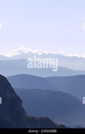 Gebirgszüge von Gröden mit Morgennebel bedeckt auf der Seiser Alm, Italien (Vertikales Foto) Stockfoto