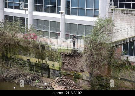 Salford, Großbritannien, 15th. Februar 2022. Ein Teil einer Ufermauer ist in der Nähe der Blackfriars Bridge in Salford, Greater Manchester, England, Großbritannien, in den Fluss Irwell eingestürzt. Auf dem Fußweg über dem Kollaps wurden Absperrbarrieren errichtet, aber einige Menschen ignorieren die Schließung und nutzen den Fußweg trotz des Sicherheitsrisikos immer noch. Quelle: Terry Waller/Alamy Live News Stockfoto