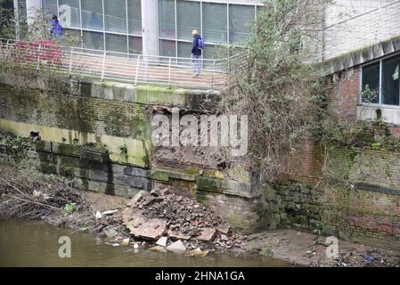 Salford, Großbritannien, 15th. Februar 2022. Ein Teil einer Ufermauer ist in der Nähe der Blackfriars Bridge in Salford, Greater Manchester, England, Großbritannien, in den Fluss Irwell eingestürzt. Auf dem Fußweg über dem Kollaps wurden Absperrbarrieren errichtet, aber einige Menschen ignorieren die Schließung und nutzen den Fußweg trotz des Sicherheitsrisikos immer noch. Quelle: Terry Waller/Alamy Live News Stockfoto