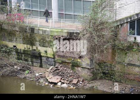 Salford, Großbritannien, 15th. Februar 2022. Ein Teil einer Ufermauer ist in der Nähe der Blackfriars Bridge in Salford, Greater Manchester, England, Großbritannien, in den Fluss Irwell eingestürzt. Auf dem Fußweg über dem Kollaps wurden Absperrbarrieren errichtet, aber einige Menschen ignorieren die Schließung und nutzen den Fußweg trotz des Sicherheitsrisikos immer noch. Quelle: Terry Waller/Alamy Live News Stockfoto