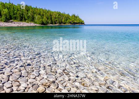 Weiße, steinige Küste entlang des Huron-Sees. Kristallklares Wasser zeigt Kalksteinfelsen. Little Cove Beach, Bruce Peninsula National Park, Ontario, Kanada Stockfoto