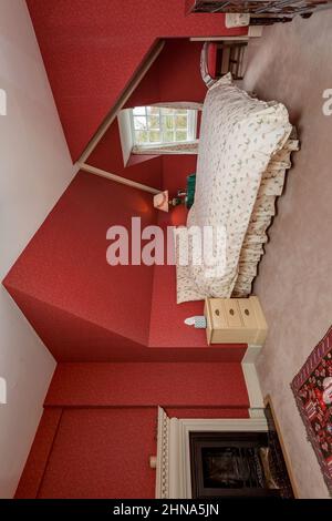 Newmarket, Suffolk - Oktober 23 2014: Dachgeschoss- oder Dienstzimmer im großen Landhaus mit schrägen Decken und offenem Kamin. Stockfoto