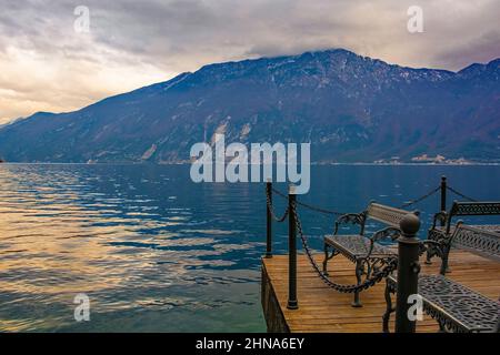 Eine Bank am Ufer der italienischen Stadt Limone sul Garda am Nordostufer des Gardasees in der Lombardei, Italien Stockfoto