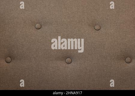 Hintergrund brauner Samt-Kapitonstoff, Veloursleder, Samt mit Knöpfen, Sofahintergrund. Couch-Sitz. Nahaufnahme Makrofoto. Stockfoto