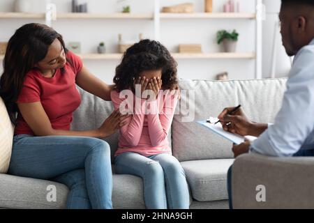 afroamerikanisches Mädchen weint während der Therapiesitzung mit Kinderpsychologin Stockfoto