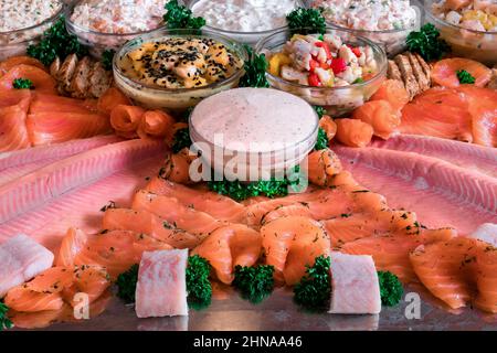 Anordnung von verschiedenen Fisch-Gourmet-Speisen, schön auf einer Stahlplatte angeordnet Stockfoto