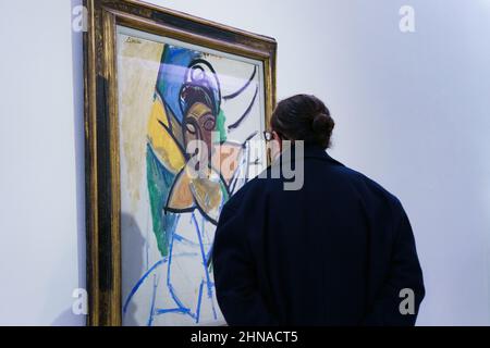 Madrid, Spanien. 15th. Februar 2022. Die Besucher beobachten das Gemälde „Frau“ der Sammlung Fondation Beyeler während der Ausstellung „Picasso Faces and Figures“ in der Königlichen Akademie der Schönen Künste in Madrid.die Ausstellung basiert auf den vielfältigen und ausdrucksstarken Darstellungen von Körpern, Gesichtern und Erscheinungen in einer ausgewählten Gruppe von Werken von Pablo Picasso, Bietet eine beispielhafte Perspektive auf seine umfangreiche Produktion, vom Proto-Kubismus bis zu seinen späten Kreationen. Kredit: SOPA Images Limited/Alamy Live Nachrichten Stockfoto