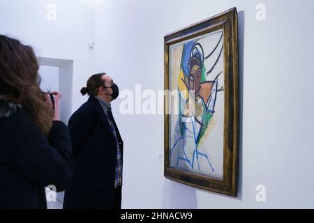 Madrid, Spanien. 15th. Februar 2022. Die Besucher beobachten das Gemälde „Frau“ der Sammlung Fondation Beyeler während der Ausstellung „Picasso Faces and Figures“ in der Königlichen Akademie der Schönen Künste in Madrid.die Ausstellung basiert auf den vielfältigen und ausdrucksstarken Darstellungen von Körpern, Gesichtern und Erscheinungen in einer ausgewählten Gruppe von Werken von Pablo Picasso, Bietet eine beispielhafte Perspektive auf seine umfangreiche Produktion, vom Proto-Kubismus bis zu seinen späten Kreationen. Kredit: SOPA Images Limited/Alamy Live Nachrichten Stockfoto