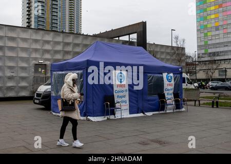 London, Großbritannien. 15th. Februar 2022. Eine Frau geht an der mobilen Teststelle des NHS covid-19 vorbei.die Bereitstellung kostenloser Covid-19-Tests in England wird derzeit überprüft, da die Rate der Covid-19-Infektion im Land sinkt. Die britische Regierung wird am 21st. Februar eine mögliche weitere Lockerung der Covid-19-Beschränkungen in England bekanntgeben. Die neue Strategie des „Lebens mit COVID-19“ der britischen Regierung umfasst die Beendigung der obligatorischen Selbstisolierung nach dem Test von COVID-19-positiv. Kredit: SOPA Images Limited/Alamy Live Nachrichten Stockfoto