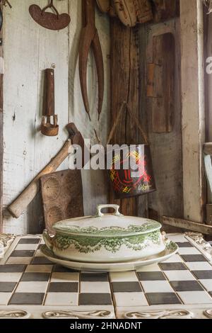 Antike Porzellanschale mit Deckel auf Schachbrett und andere Vintage-Objekte in alten rustikalen Holzdiele Kabine. Stockfoto