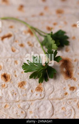 Lavasch rollte auf einem hölzernen Hintergrund, dünnes traditionelles orientalisches Brot, armenisches Fladenbrot-Makro, Nahaufnahme Stockfoto