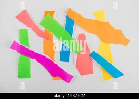 Zerrissene Papierstreifen in Neonfarbe isoliert auf weißem Hintergrund. Stockfoto