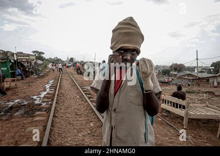 Nairobi, Kenia. 14th. Februar 2022. Ein Schüler nimmt eine Boxhaltung in den belebten Straßen der Slums von Kibera in Nairobi ein. Auf der anderen Seite der belebten Straßen in den Slums von Kibera, wo sich die meisten Bewohner hauptsächlich auf ihre täglichen Geschäfte und verschiedene Aktivitäten konzentrierten, Einige Einheimische nahmen ihren Tag außerhalb der Arbeit und beschlossen, Liebe und Glück mit anderen Gemeindemitgliedern während des Valentinstags zu teilen, während sie ihre schönen bunten, schönen Outfits trugen und dabei kostenlose Blumen verteilten. (Bild: © Donwilson Odhiambo/ZUMA Press Wire) Stockfoto