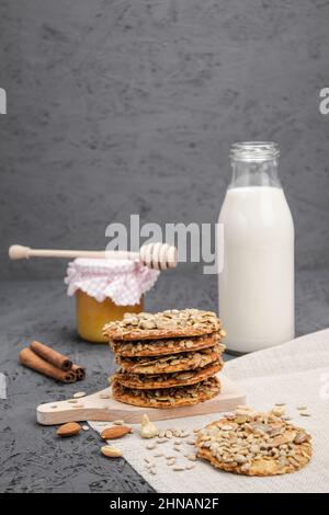 Süße Kekse und Milch mit Honig auf einem hölzernen Hintergrund. Hintergrund mit Kopierbereich Stockfoto