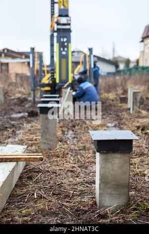 Angetriebene, gegossene Pfähle mit Stahlplatte oder -Kopf, Fundament für Holzrahmenhaus, Bodenarbeiten Stockfoto