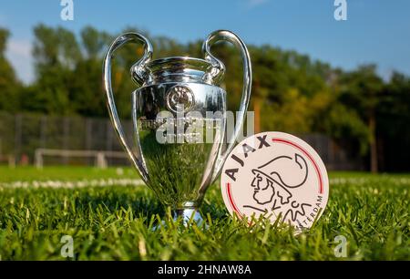 30. August 2021, Amsterdam, Niederlande. Das Emblem des AFC Ajax Fußballvereins und des UEFA Champions League Cups auf dem grünen Rasen des Stadions. Stockfoto