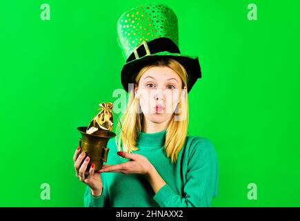 Blonde Mädchen in grünen Hut mit Topf mit Gold und senden Kuss. St. Patricks Tag. Irische Traditionen Stockfoto