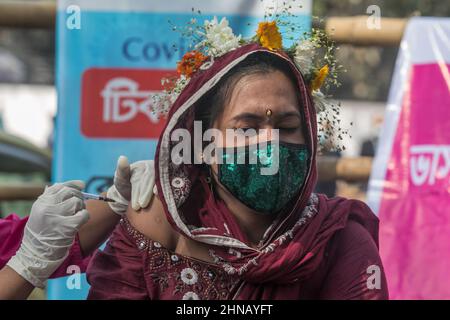 Dhaka, Bangladesch. 14th. Februar 2022. Ein Gesundheitsmitarbeiter impft eine Transgender-Person mit einer Dosis des Janssen COVID-19-Impfstoffs während einer Impfkampagne gegen Transgender-Gemeinschaften und Obdachlose in Central Shaheed Minar, Dhaka. Kredit: SOPA Images Limited/Alamy Live Nachrichten Stockfoto