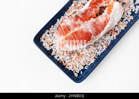 Gegrilltes, frisch-rohes Lachssteak mit großem grobem rosafarbenem Salz. Gesunde Meeresfrüchte Stockfoto