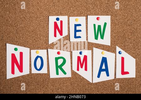 Die Worte New Normal stehen in bunten Buchstaben auf festgestecktem Papier, verändern die Welt, unterschiedliche Standpunkte Stockfoto