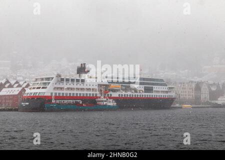 Auto- und Passagierfähre Trollfjord am Bryggen Kai, im Hafen von Bergen, Norwegen. Bunkertanker Bergen Tank liefert neben Troll Kraftstoff Stockfoto