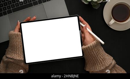 Grafikdesignerin skizziert ihr grafisches Bild auf einem digitalen Tablet-Computer auf ihrem modernen Schreibtisch. Draufsicht Stockfoto