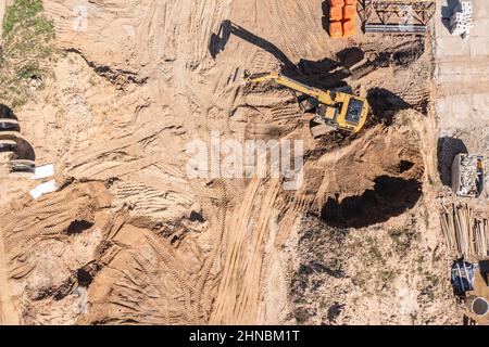 Luftaufnahme des Industriebaggers, der auf der Baustelle arbeitet. Drohnenfoto von oben. Stockfoto