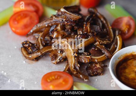 Selektiver Fokus auf gebratenes Schweinehaar mit Tomaten Sellerie und Sauce mit Sesam bestreut Stockfoto