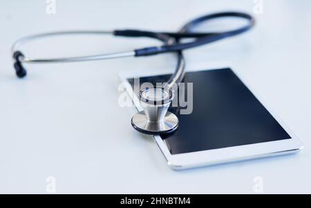 Digitalisieren Ihrer Diagnose. Aufnahme eines Stethoskops und eines digitalen Tablets auf einem Tisch. Stockfoto