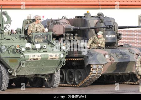 Bemowo Pikie, Polen. 11. Februar 2022. U.S. Army PFC. Moreno Chi, mit dem 1st Bataillon, 185th Infanterie-Regiment, Battle Group Poland, links, chattet mit einem rumänischen Infanteristen während einer Übergabezeremonie im Bemowo Pikie Training Area am 11. Februar 2022 in Bemowo Pikie, Polen. US-Soldaten setzen sich nach Osteuropa zur Unterstützung der NATO-Verbündeten ein und verhindern russische Aggression gegenüber der Ukraine. Kredit: SSGT. Edward Siguenza/U.S. Army/Alamy Live News Stockfoto