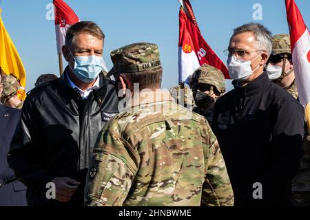 Mihail Kogalniceanu, Rumänien. 11. Februar 2022. Der rumänische Präsident Klaus Iohannis, links, und der NATO-Generalsekretär Jens Stoltenberg, rechts, sprechen mit dem US-Army-Majors Matthew Van Wagenen auf dem Mihail Kogalniceanu Air Base am 11. Februar 2022 in Mihail Kogalniceanu, Rumänien. Verstärkte NATO-Truppen haben sich nach Osteuropa entsandt, um die russische Aggression gegen die Ukraine zu verhindern. Kredit: Spc. Osvaldo Fuentes/U.S. Army/Alamy Live News Stockfoto