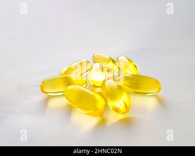 Geschlossene Kapseln mit Nahrungsergänzungsmittel: Fischöl, Omega 3, Vitamin A, Vitamin D, Vitamin D3, Vitamin E. Selektiver Fokus. Stockfoto