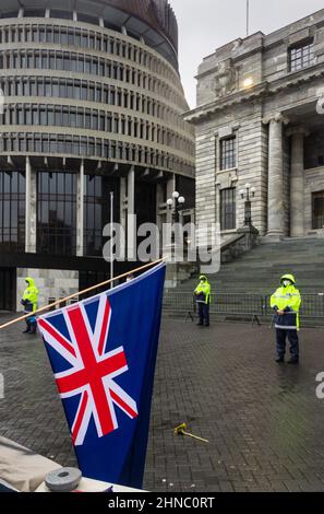 Wellington, Neuseeland. 13. Februar 2022: Während der Anti-Mandats-Konvoi-Besetzung hängt eine auf den Kopf stehende NZ-Flagge über den Barrieren im Parlament Stockfoto