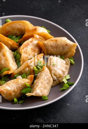 Frittierte knusprige Gyoza mit Frühlingszwiebeln. Asiatische Küche. Stockfoto