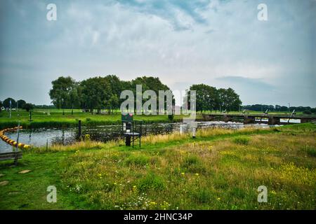 Drohnenansicht des Flusses Vecht, grünes Gras, Bäume, schöner blauer Himmel und Radweg durch das Vecht-Tal. Brücke und Wehr im Fluss. Dalfsen Stockfoto