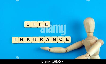 Lebensversicherungskonzept. Selektiver Fokus auf eine Puppe mit Kachel Stockfoto