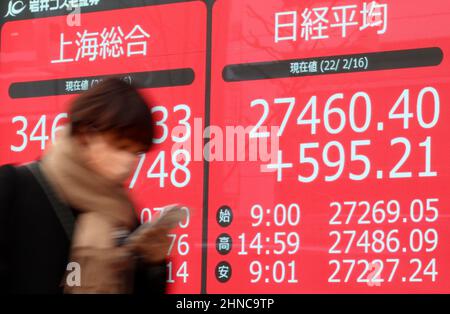 Tokio, Japan. 16th. Februar 2022. Ein Fußgänger fährt am Mittwoch, den 16. Februar 2022, vor einem Aktienkursen-Board in Tokio durch. Die japanischen Aktienkurse erholten sich um 595,21 Yen und schliefen an der Tokioter Börse bei 27.460,40 Yen. Quelle: Yoshio Tsunoda/AFLO/Alamy Live News Stockfoto