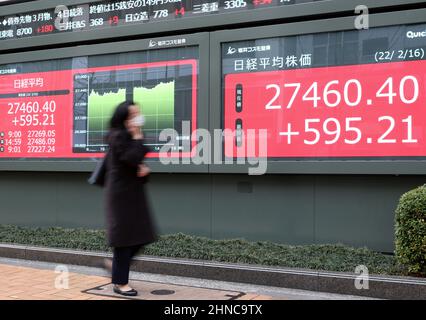 Tokio, Japan. 16th. Februar 2022. Ein Fußgänger fährt am Mittwoch, den 16. Februar 2022, vor einem Aktienkursen-Board in Tokio durch. Die japanischen Aktienkurse erholten sich um 595,21 Yen und schliefen an der Tokioter Börse bei 27.460,40 Yen. Quelle: Yoshio Tsunoda/AFLO/Alamy Live News Stockfoto