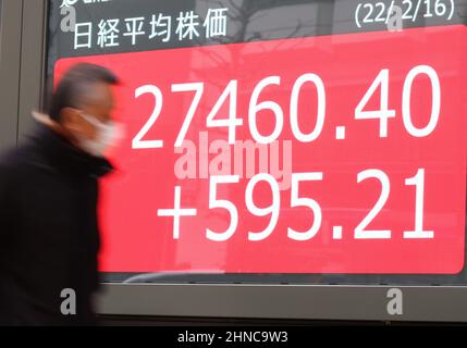 Tokio, Japan. 16th. Februar 2022. Ein Fußgänger fährt am Mittwoch, den 16. Februar 2022, vor einem Aktienkursen-Board in Tokio durch. Die japanischen Aktienkurse erholten sich um 595,21 Yen und schliefen an der Tokioter Börse bei 27.460,40 Yen. Quelle: Yoshio Tsunoda/AFLO/Alamy Live News Stockfoto