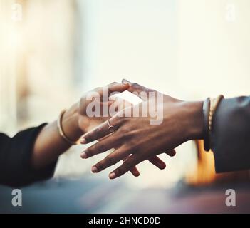 In der Stadt trifft man auf unzählige neue Menschen. Nahaufnahme von zwei Geschäftsfrauen, die sich in der Stadt die Hände schüttelten. Stockfoto