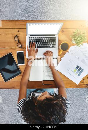 Effizienter arbeiten. Aufnahme einer unkenntlichen Frau, die von zu Hause aus arbeitet. Stockfoto